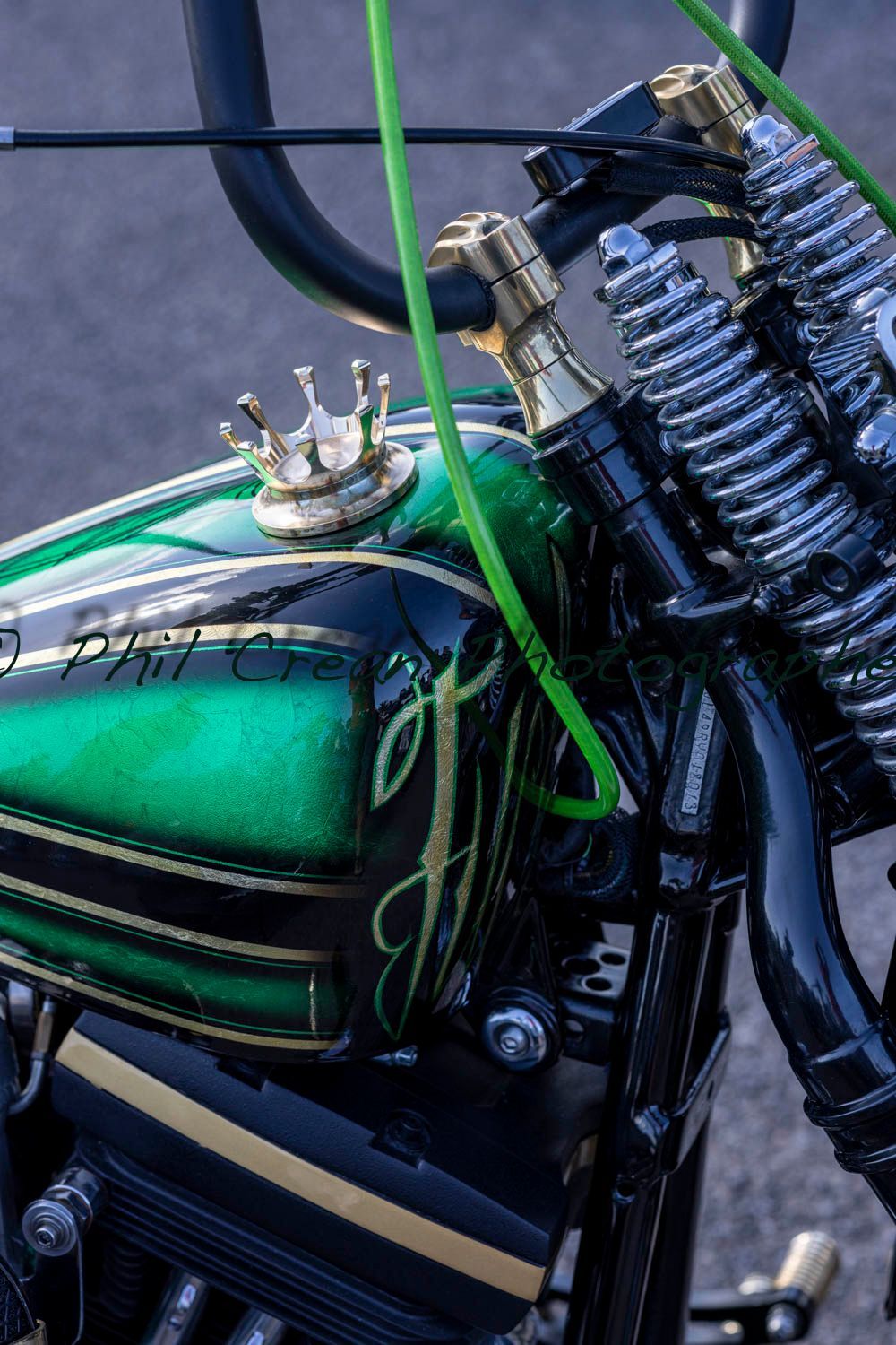 A green and black motorcycle with a crown on the tank.