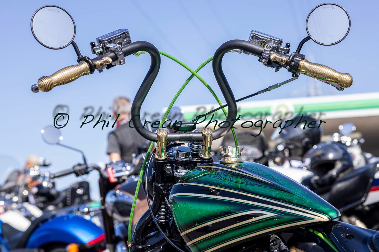 A green motorcycle is parked in front of a gas station.