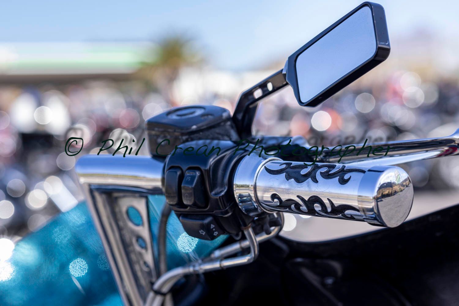 A close up of a motorcycle 's handlebars and rear view mirror.