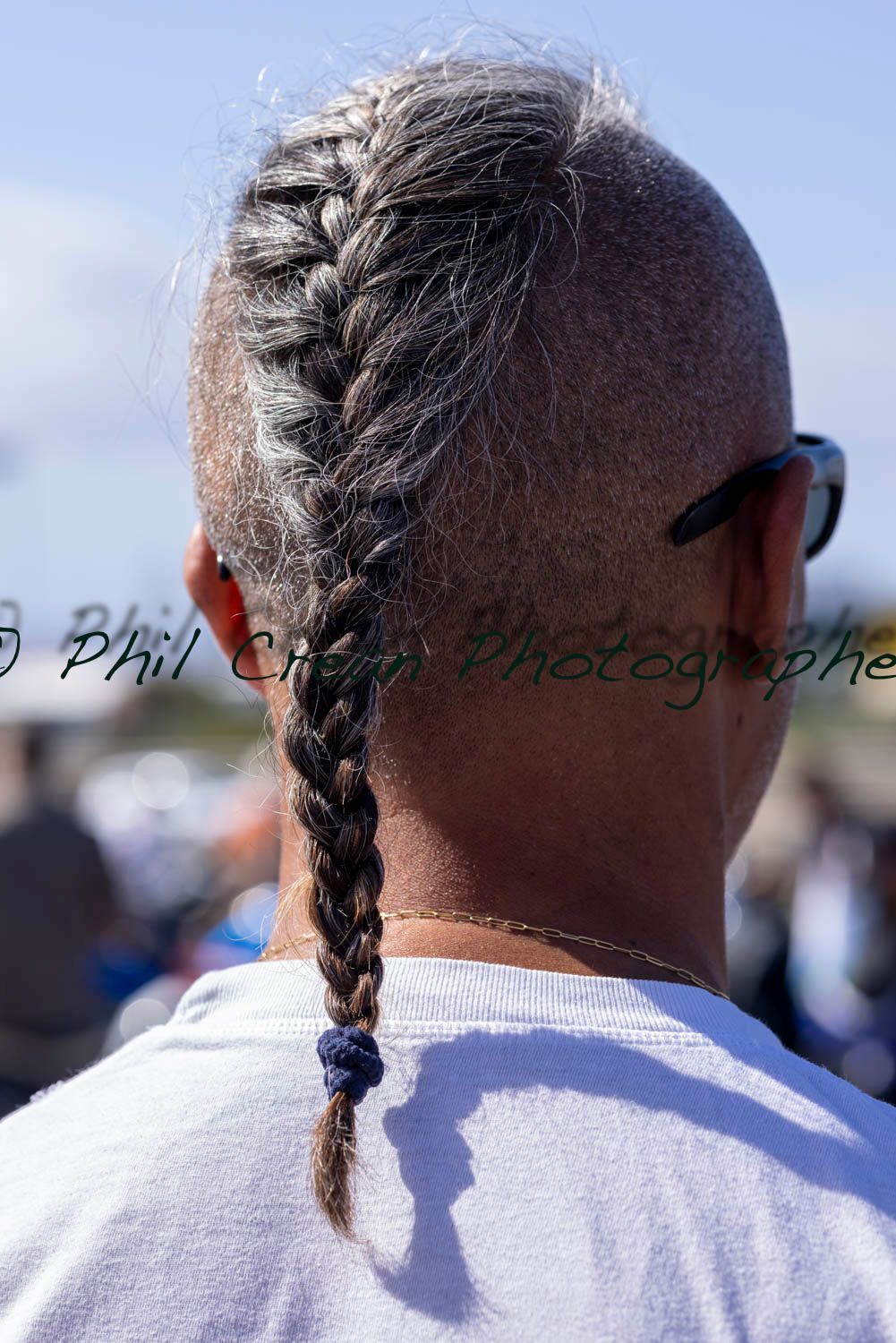The back of a man with a braid in his hair.