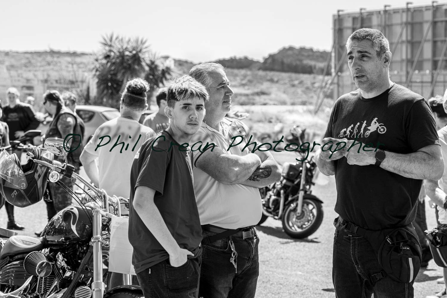 A group of men are standing next to each other in front of motorcycles.