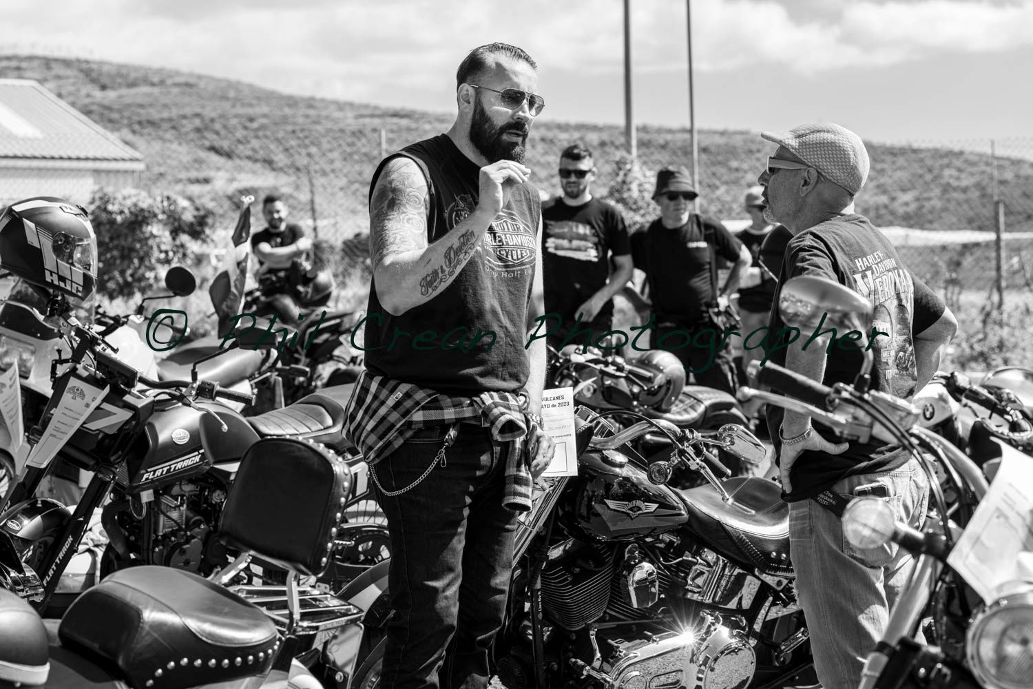 A man is standing in front of a row of motorcycles.