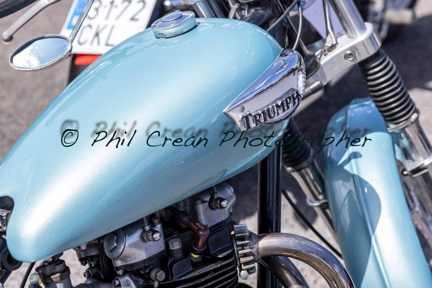 A triumph motorcycle is parked on the side of the road