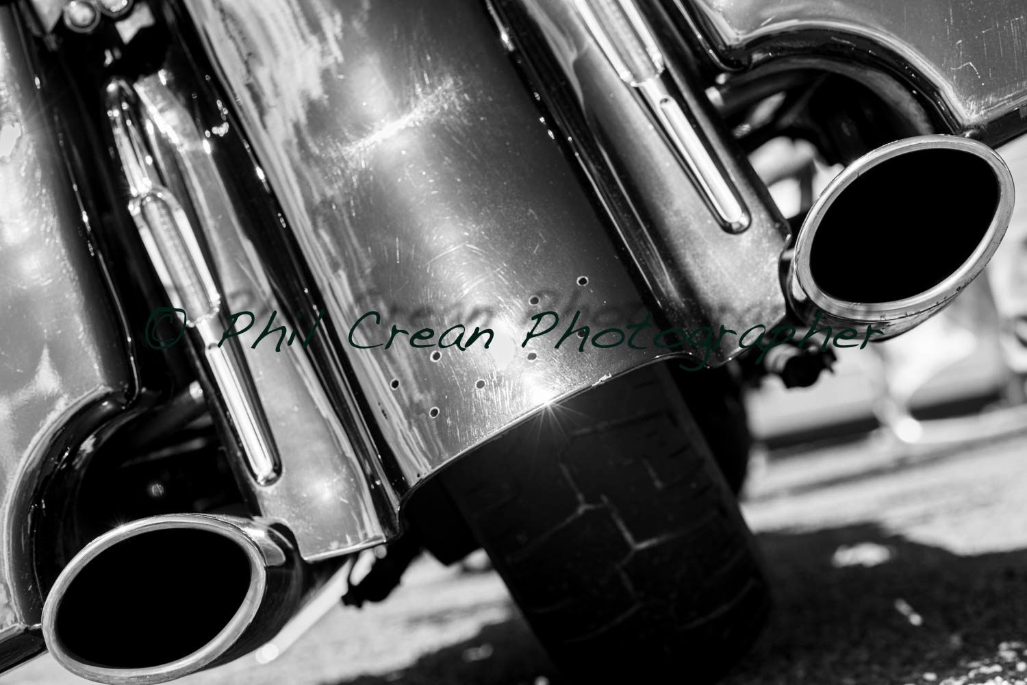 A black and white photo of the exhaust pipes of a motorcycle