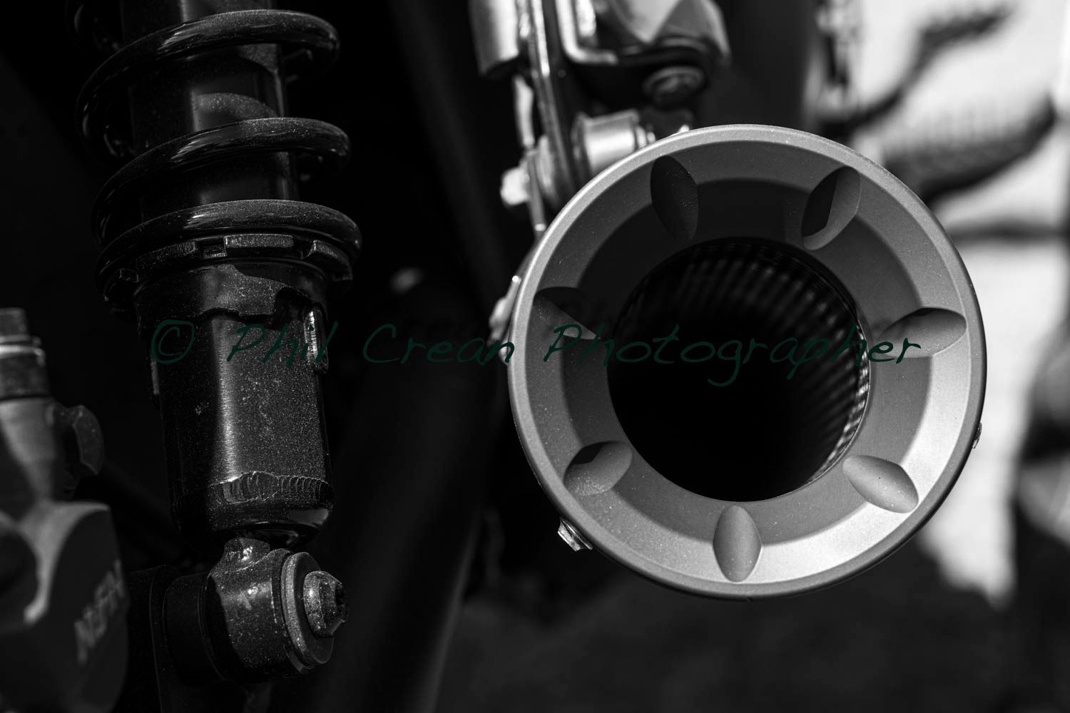 A black and white photo of a motorcycle exhaust pipe
