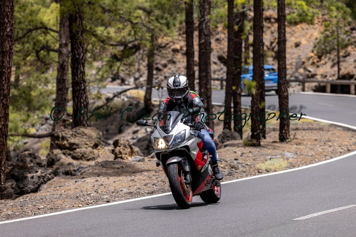 A man is riding a motorcycle down a curvy road.