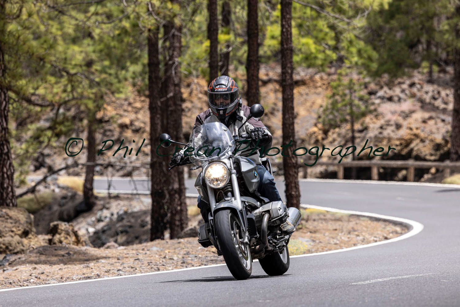 A man is riding a motorcycle down a curvy road.