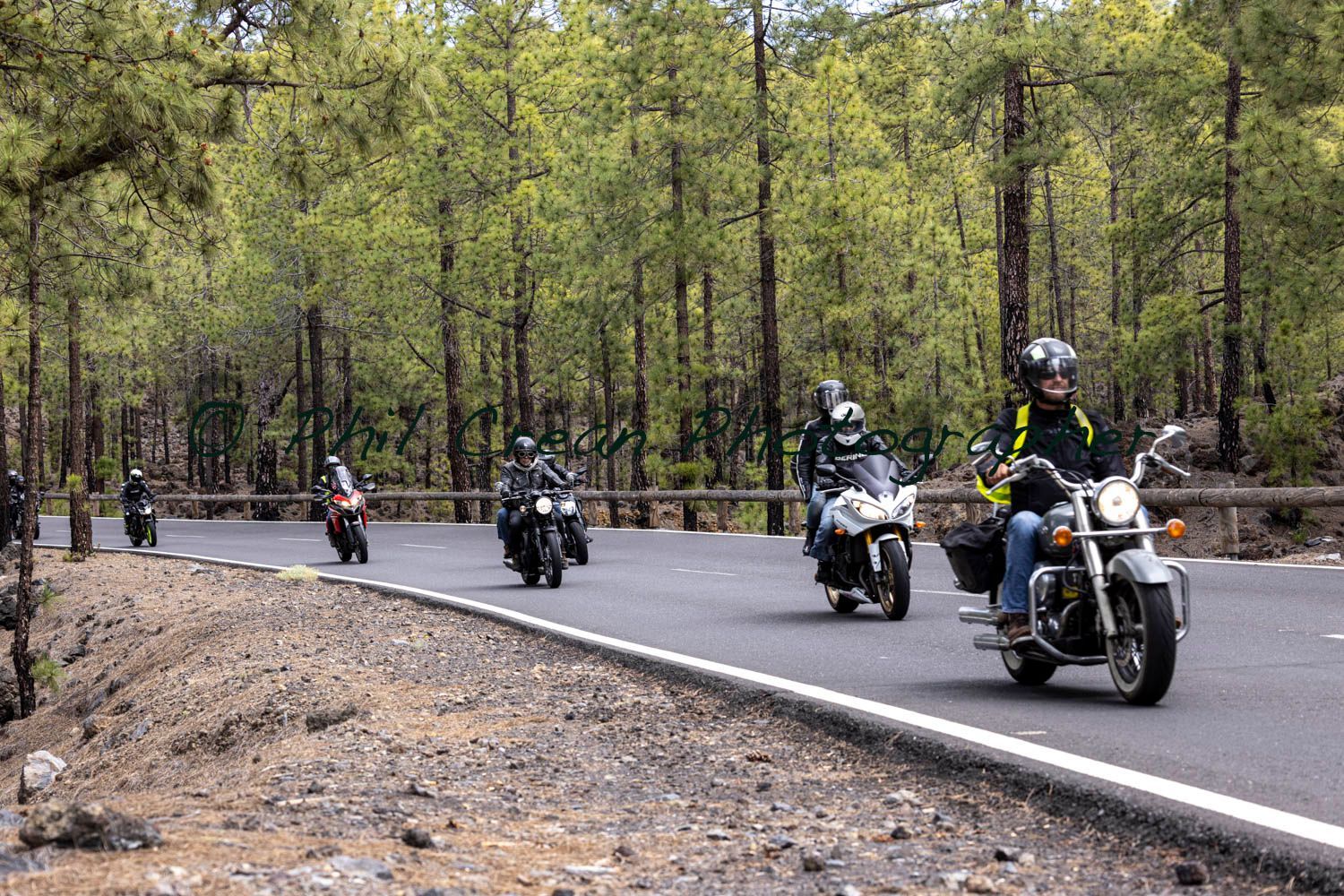 A group of people are riding motorcycles down a road.