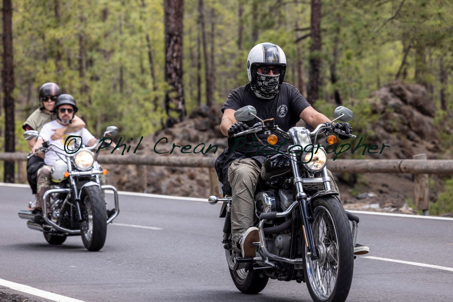 A group of people are riding motorcycles down a road.