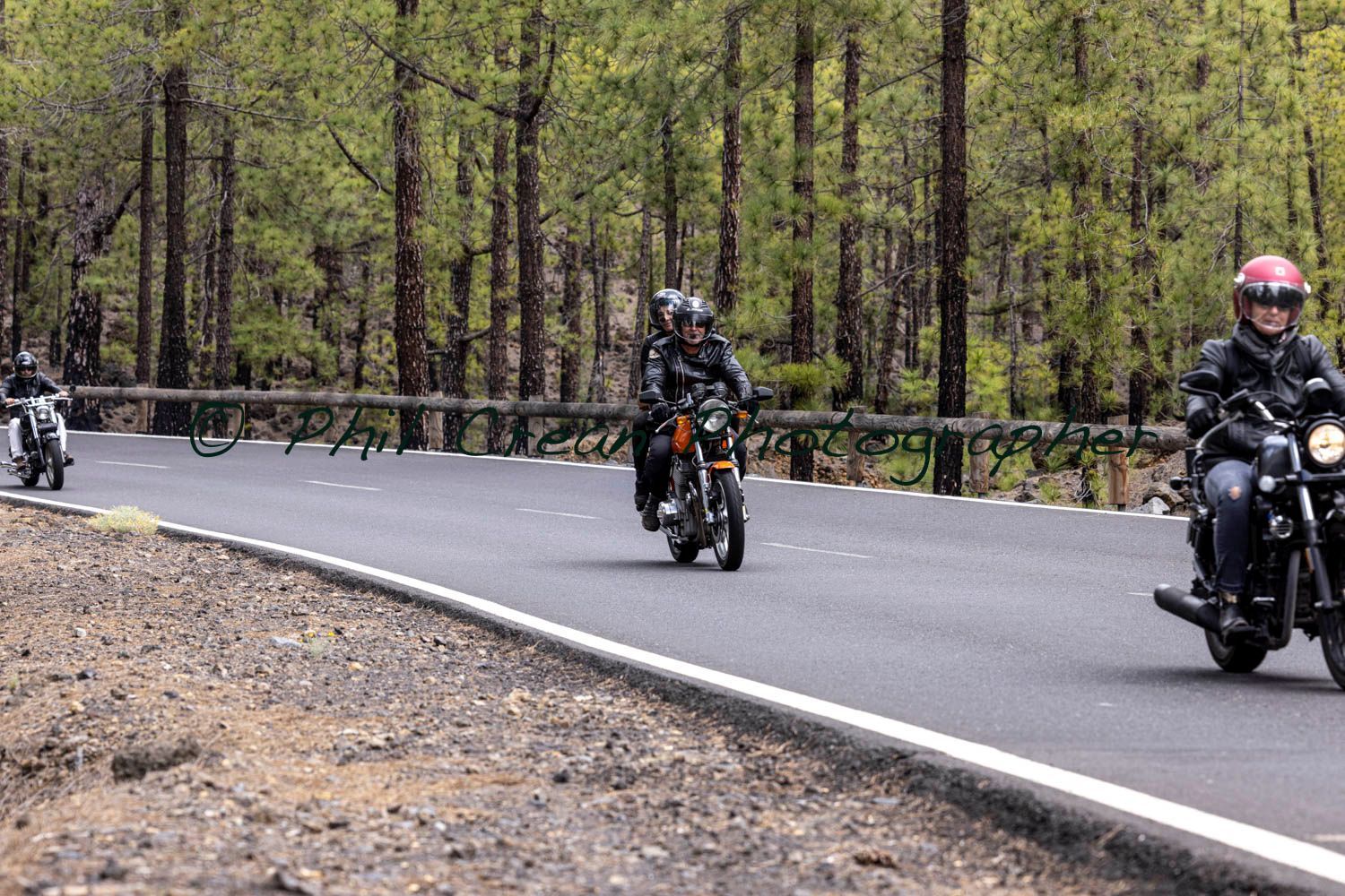 A group of people are riding motorcycles down a road.