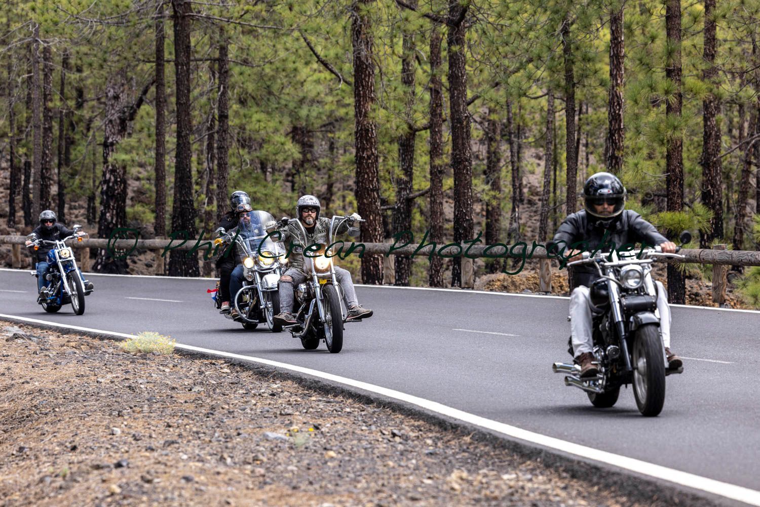 A group of people are riding motorcycles down a road.