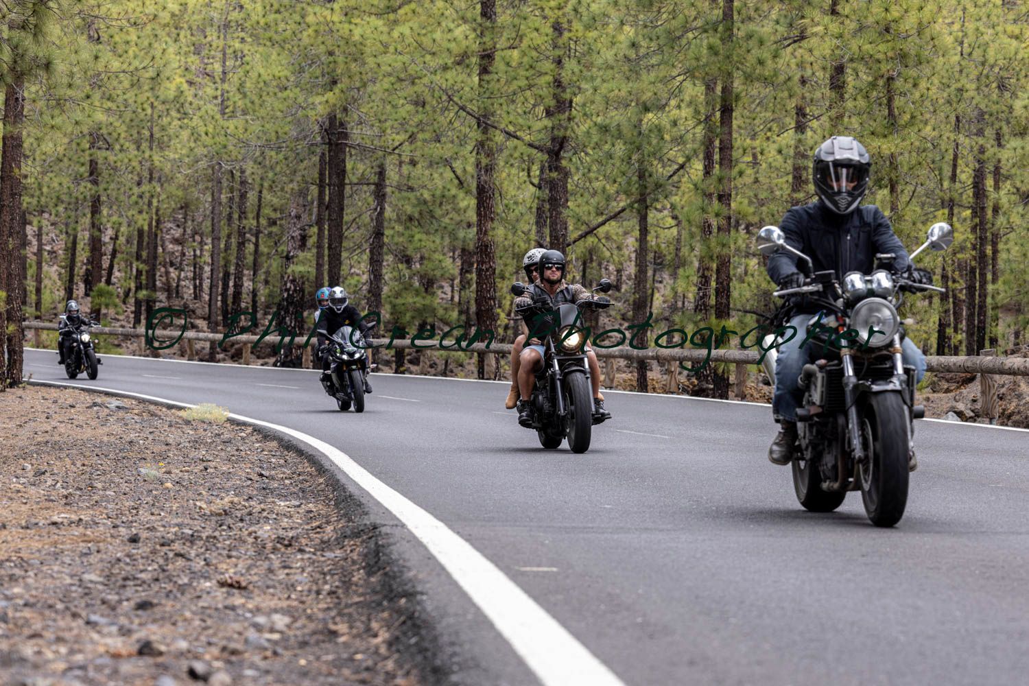A group of people are riding motorcycles down a road.
