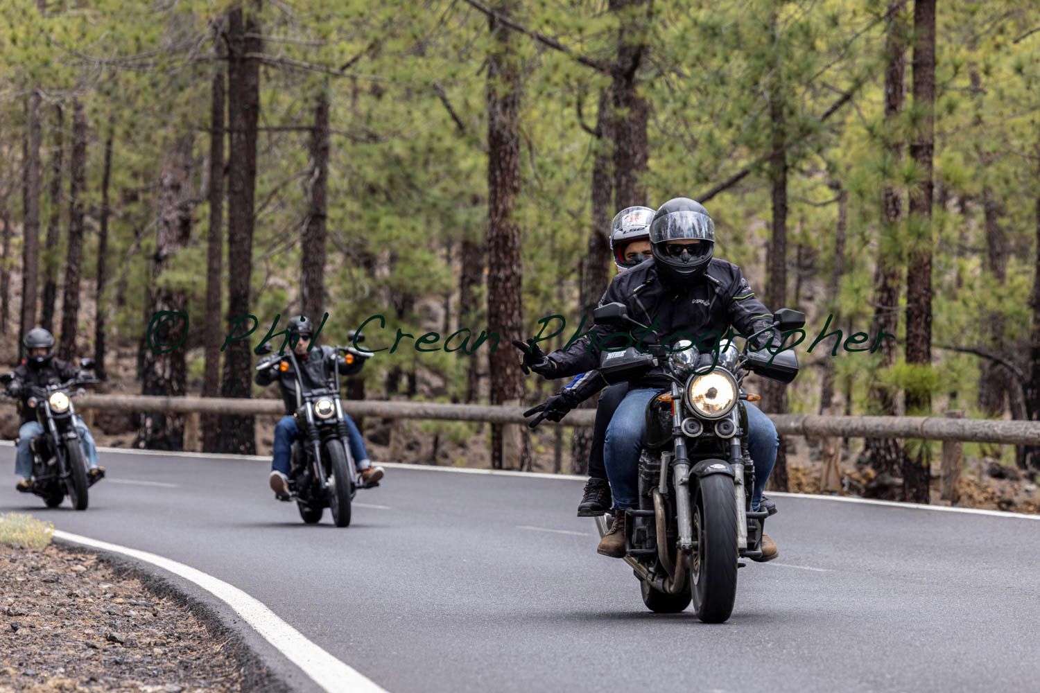 A group of people are riding motorcycles down a road.