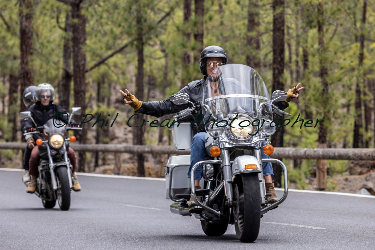 A group of people are riding motorcycles down a road.