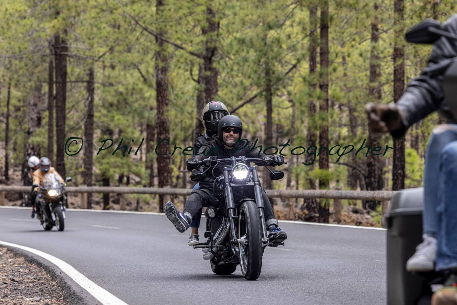 A group of people are riding motorcycles down a road.