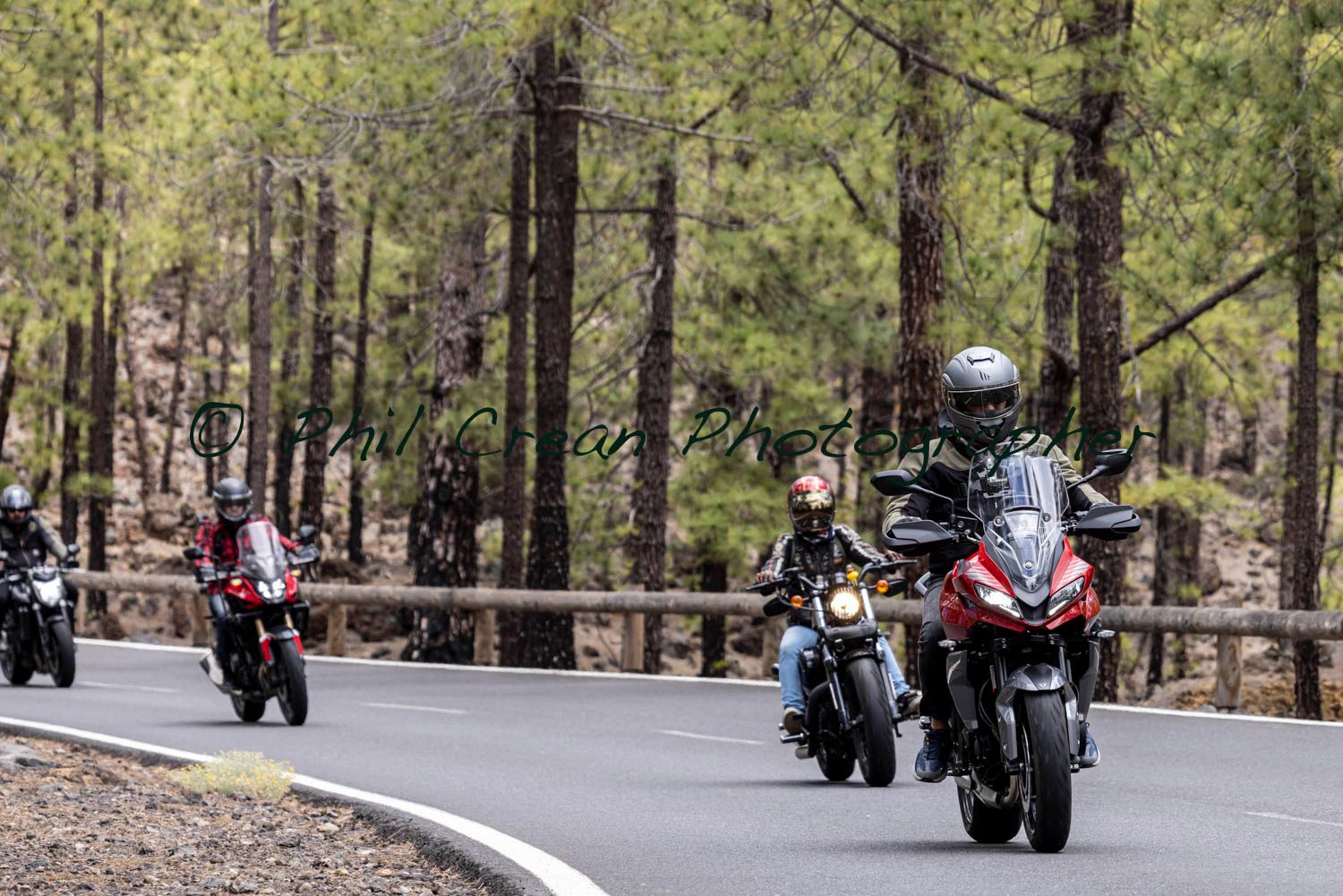 A group of people are riding motorcycles down a road.