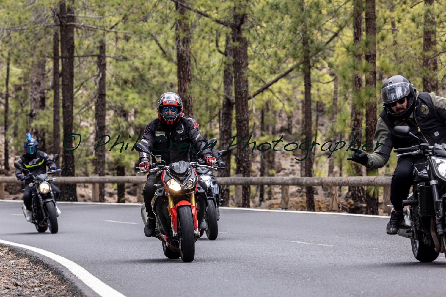 A group of people are riding motorcycles down a road.