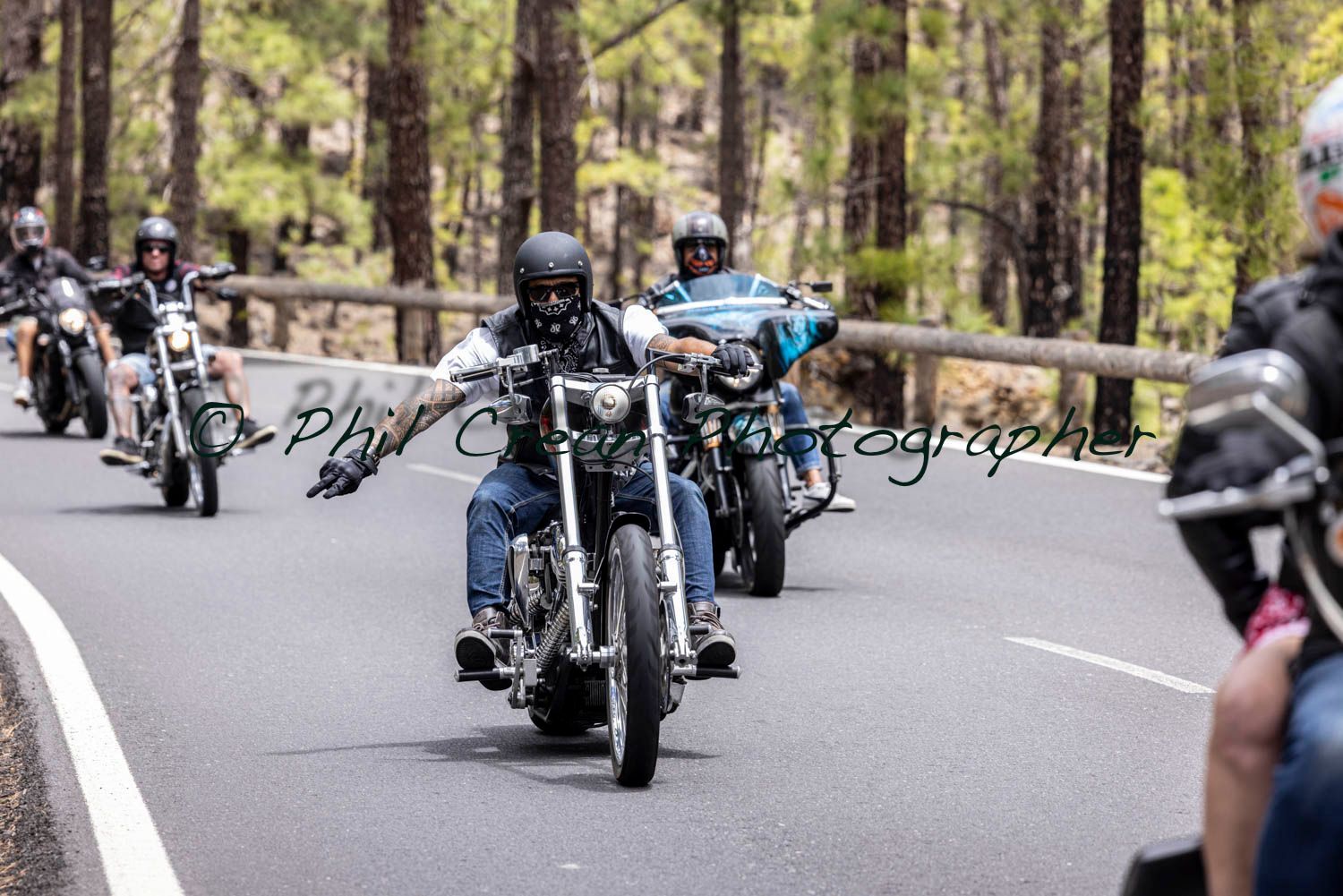 A group of people are riding motorcycles down a road.
