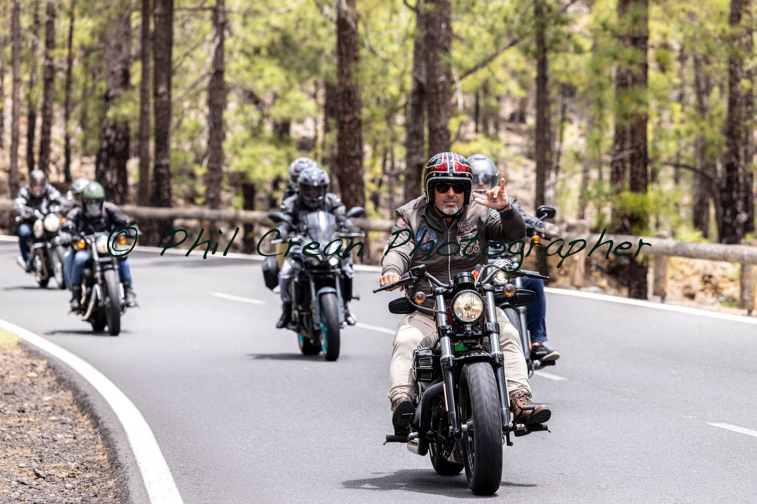 A group of people are riding motorcycles down a road.