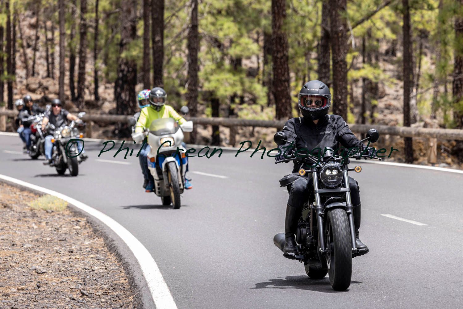 A group of people are riding motorcycles down a road.
