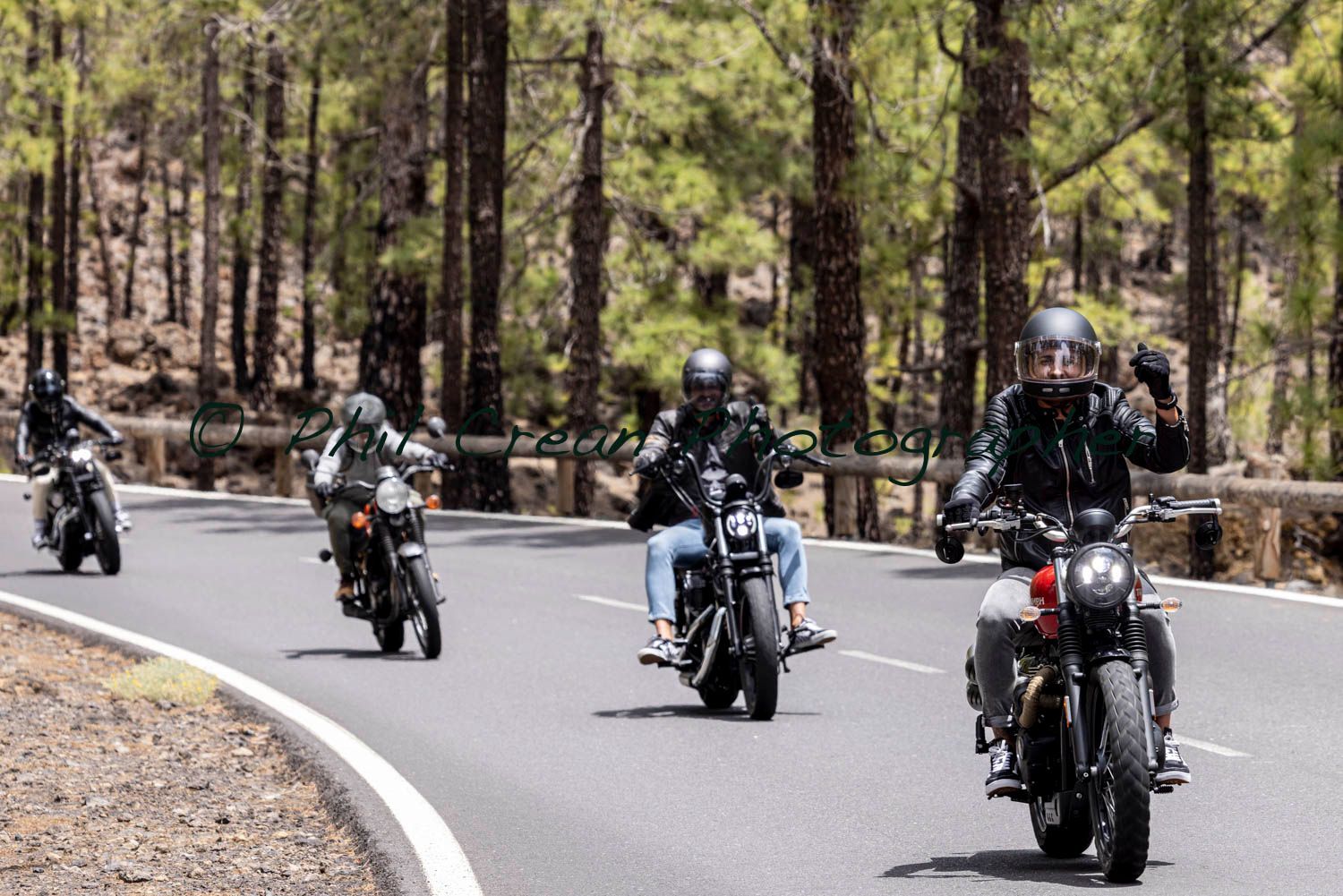 A group of people are riding motorcycles down a road.