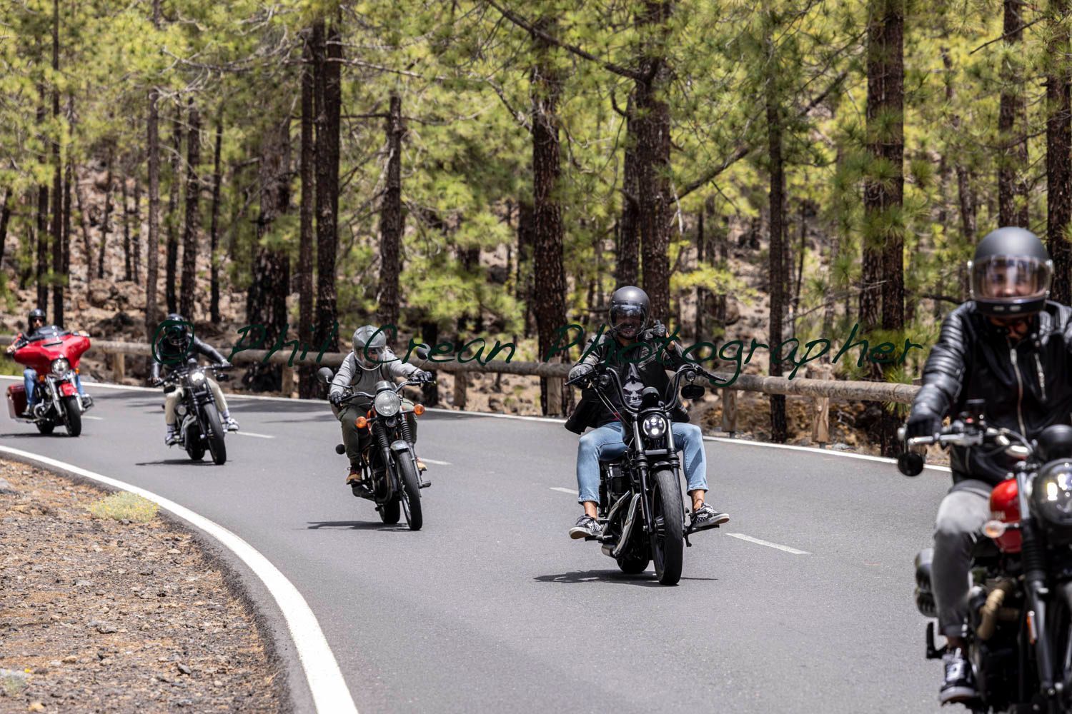 A group of people are riding motorcycles down a road.