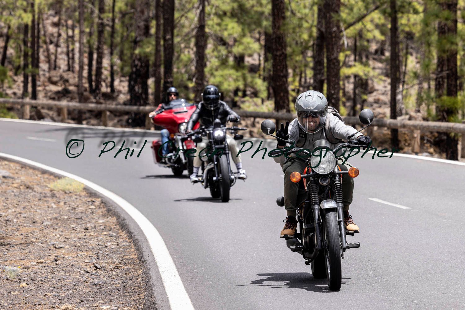 A group of people are riding motorcycles down a road.