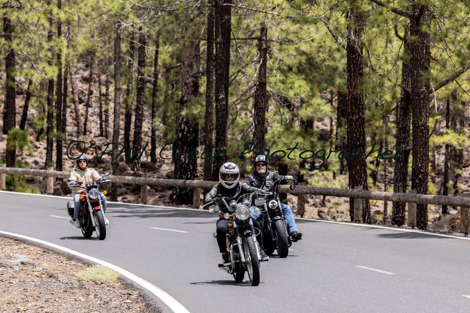 A group of people are riding motorcycles down a curvy road.
