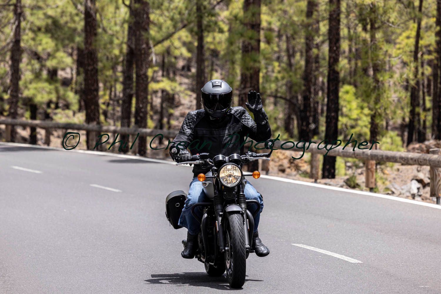 A man is riding a motorcycle down a road.