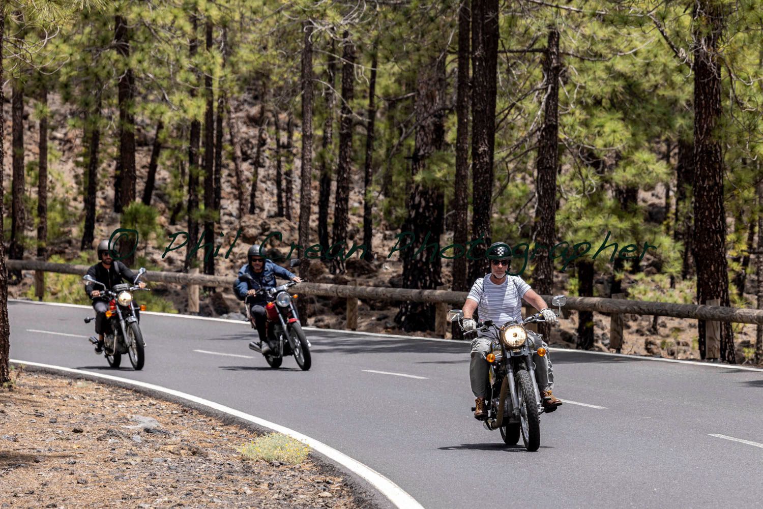 A group of people are riding motorcycles down a road.