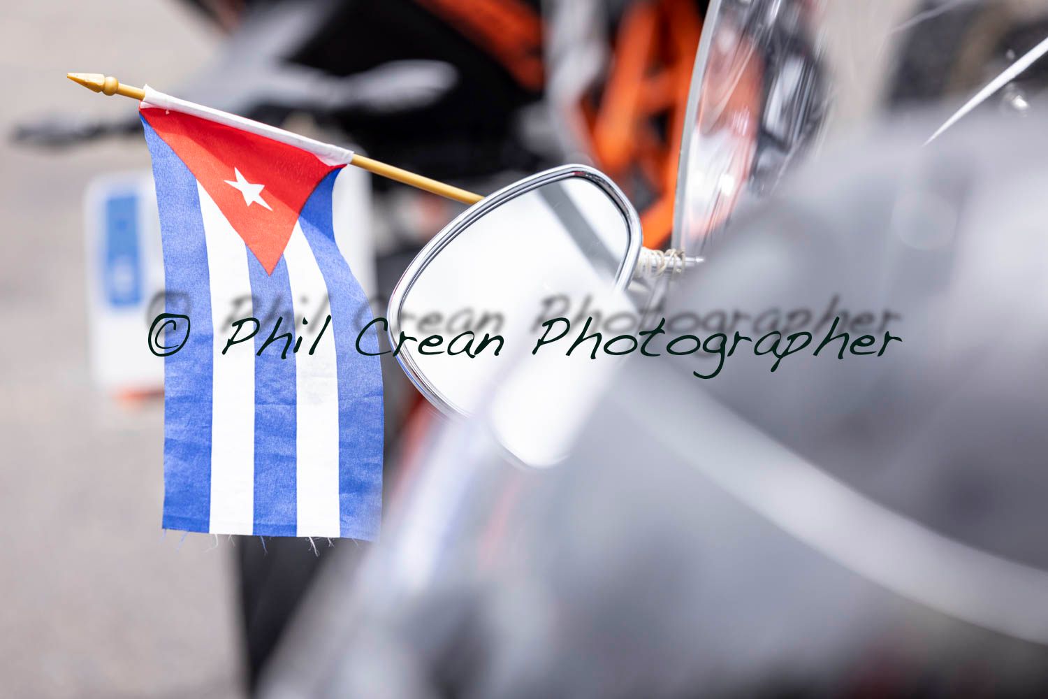A small cuban flag is attached to the side mirror of a motorcycle