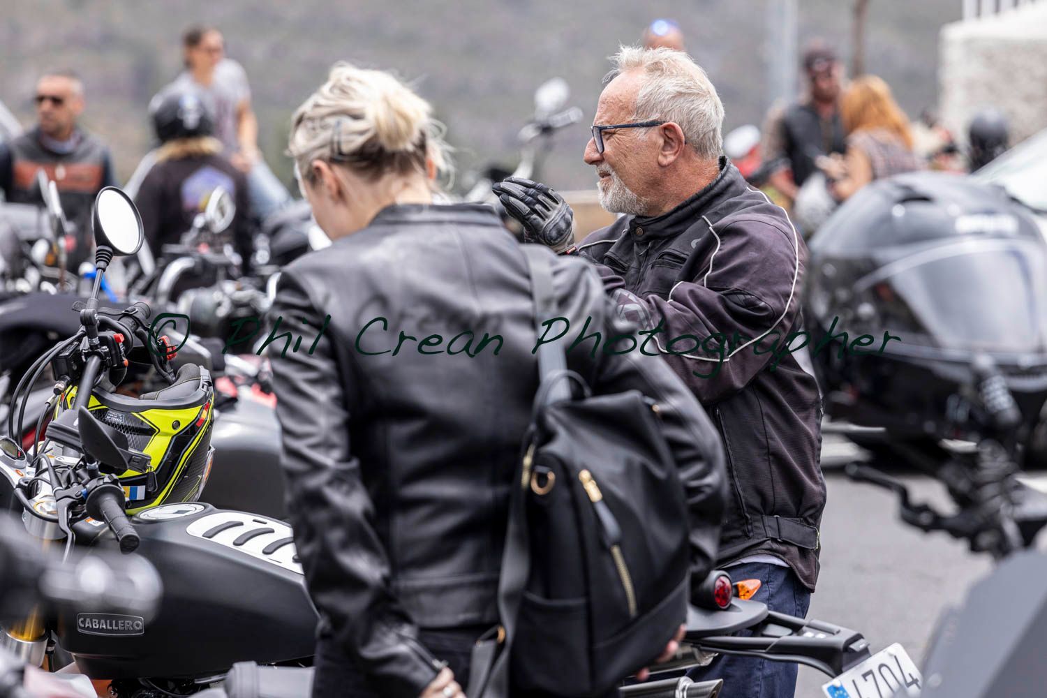 A man and a woman are standing next to a motorcycle.