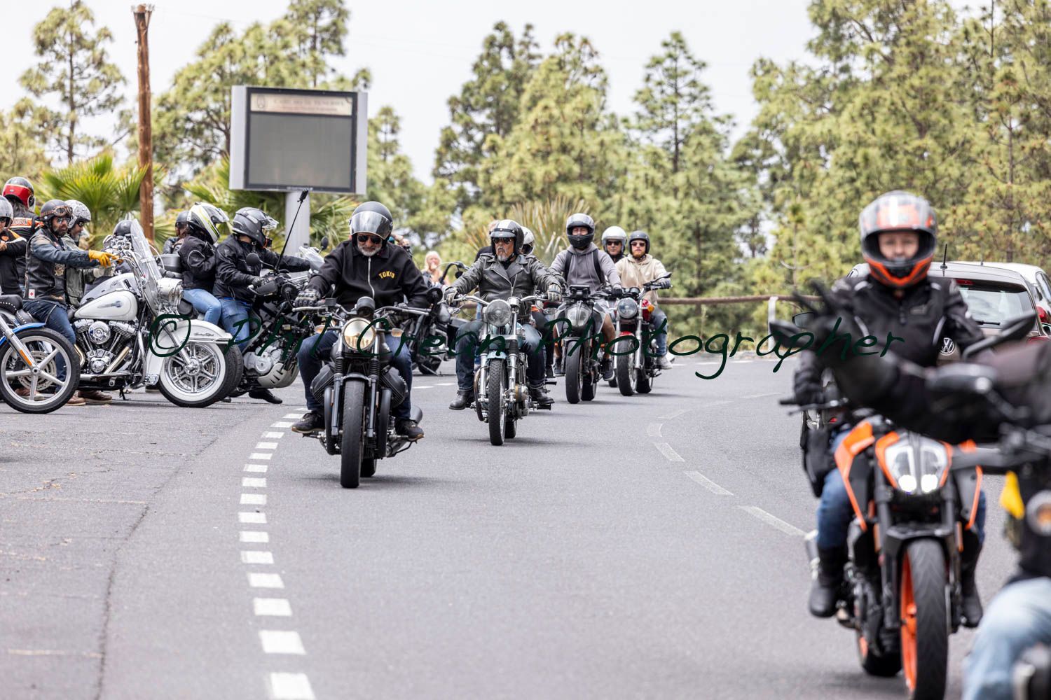 A group of people are riding motorcycles down a road.