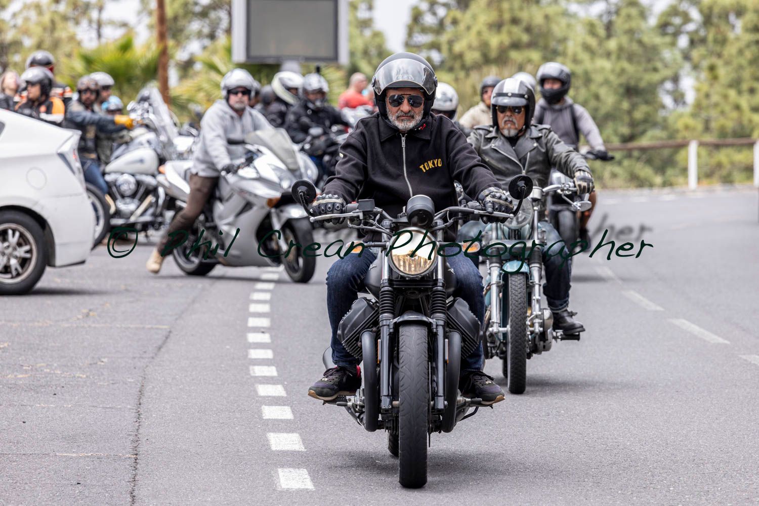 A group of people are riding motorcycles down a street.