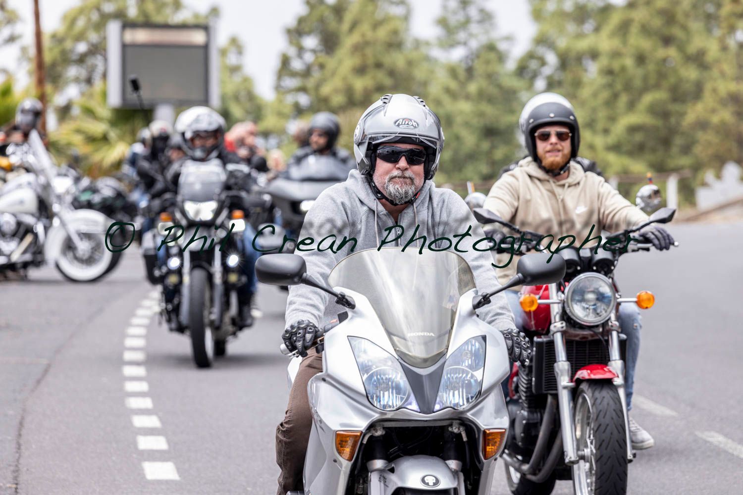 A group of people are riding motorcycles down a road.