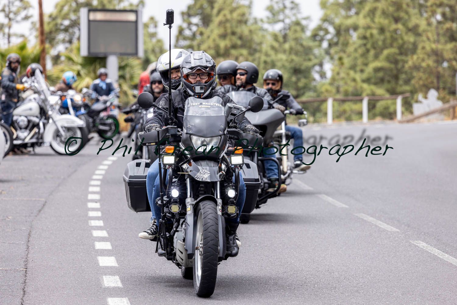 A group of people are riding motorcycles down a road.