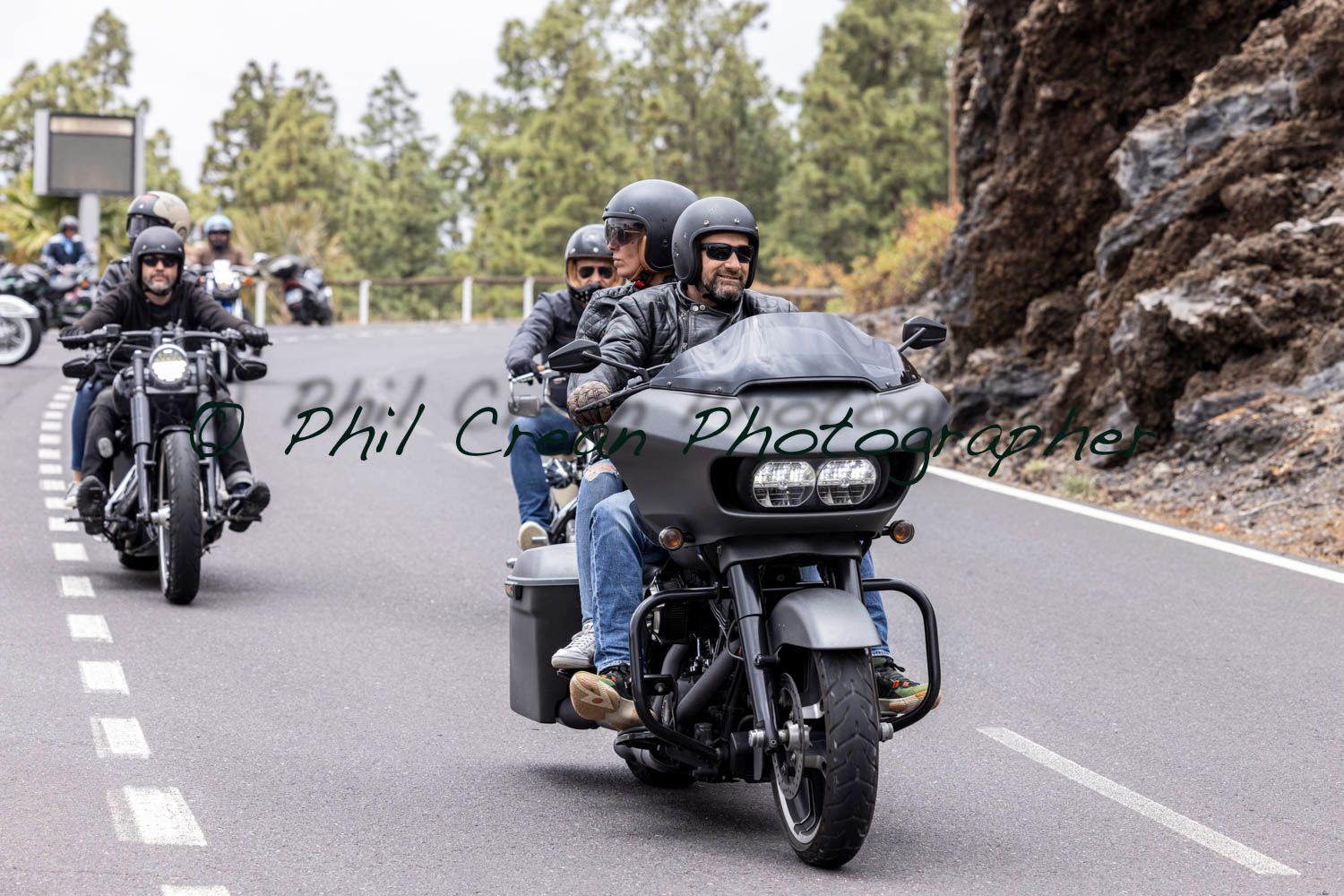 A group of people are riding motorcycles down a road