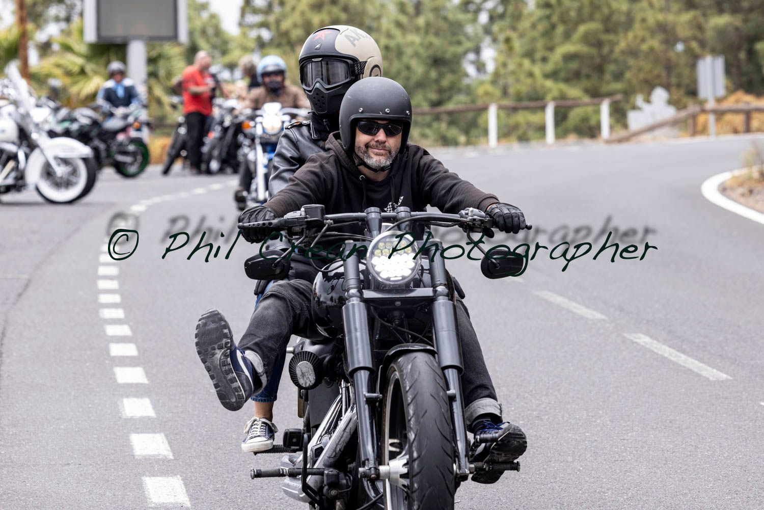 A group of people are riding motorcycles down a road.