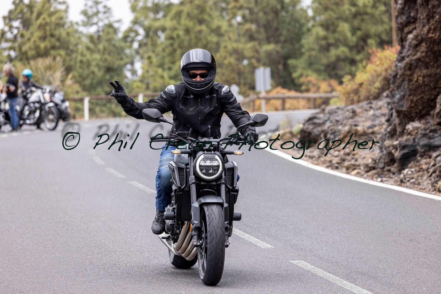 A man is riding a motorcycle down a road.