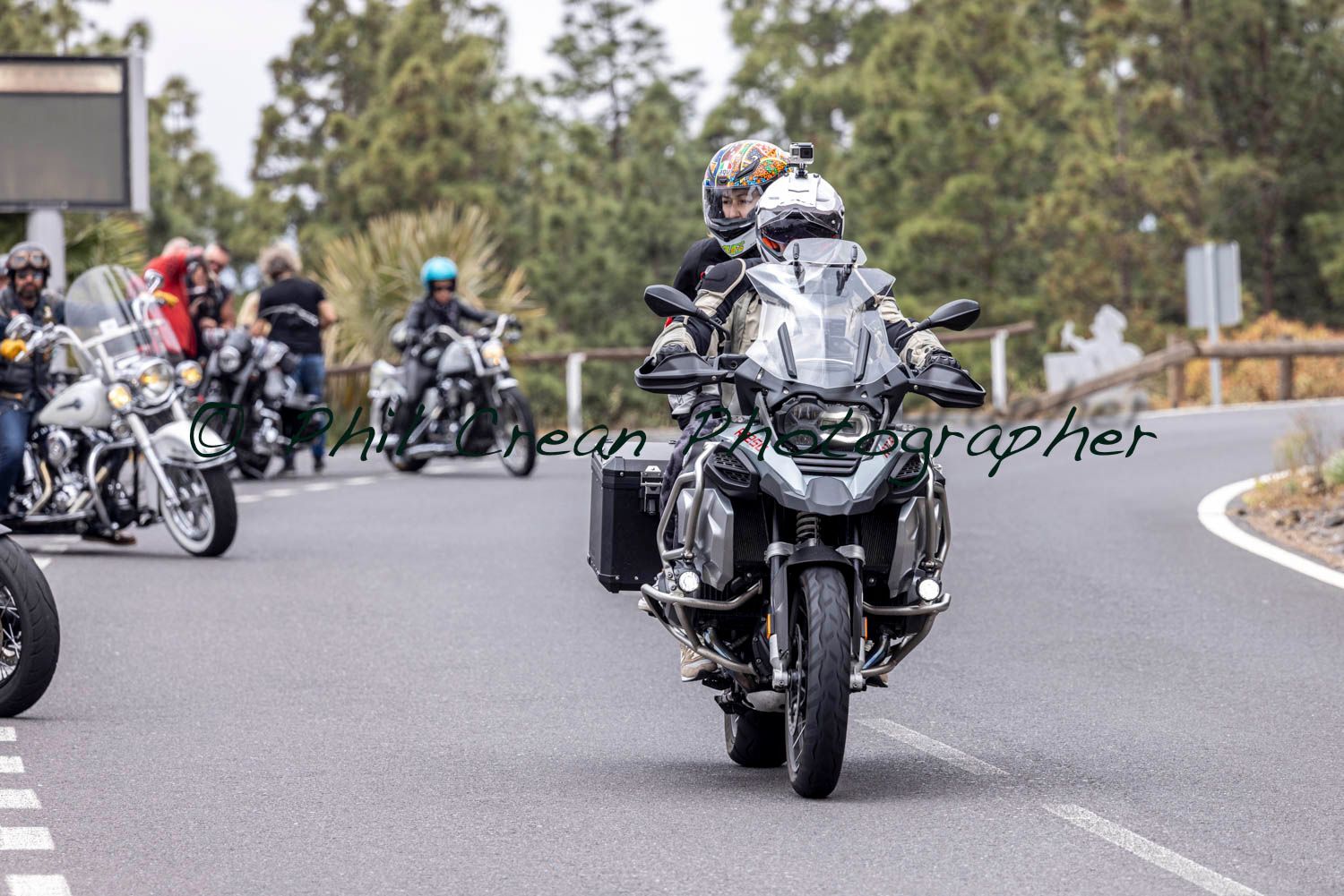 A group of people are riding motorcycles down a road.