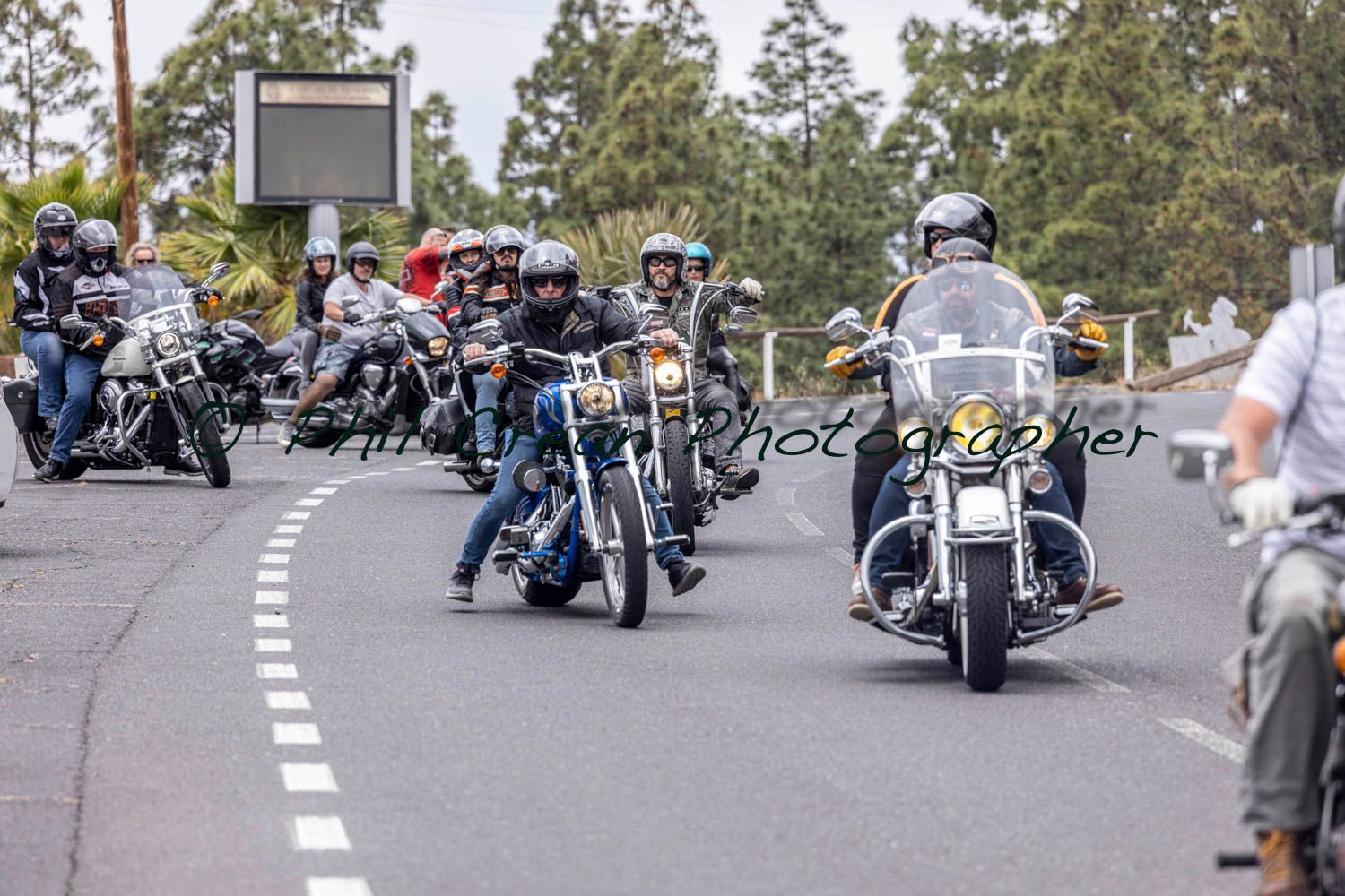 A group of people are riding motorcycles down a road.