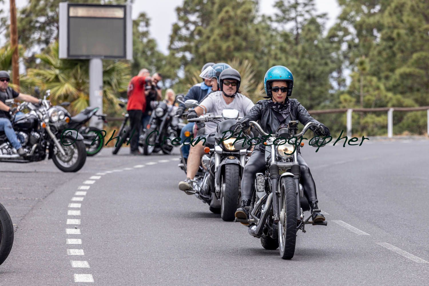A group of people are riding motorcycles down a road.