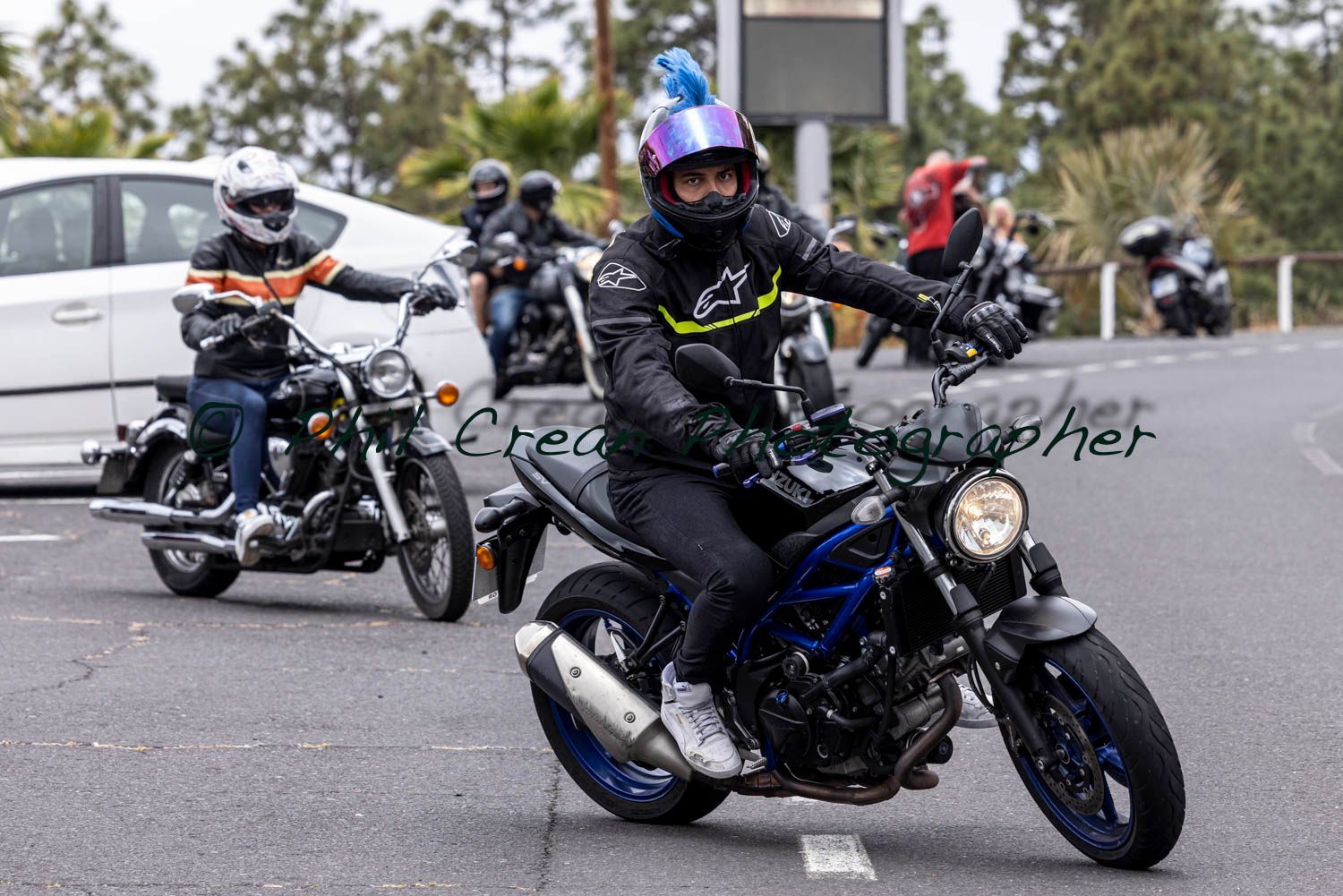 A group of people are riding motorcycles down a street.