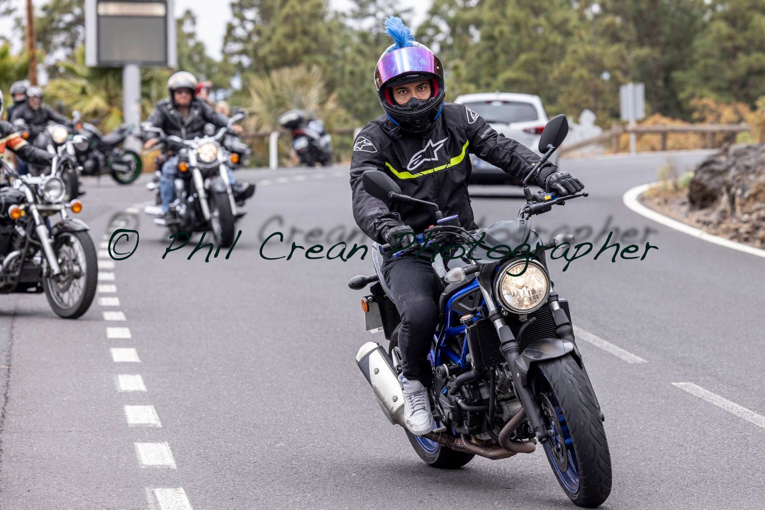 A man is riding a motorcycle down a road.