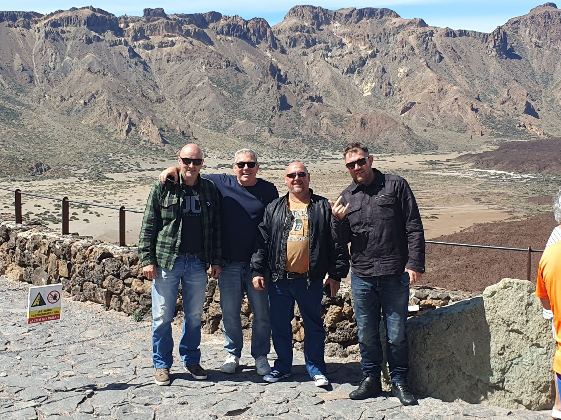 A group of men are posing for a picture with mountains in the background