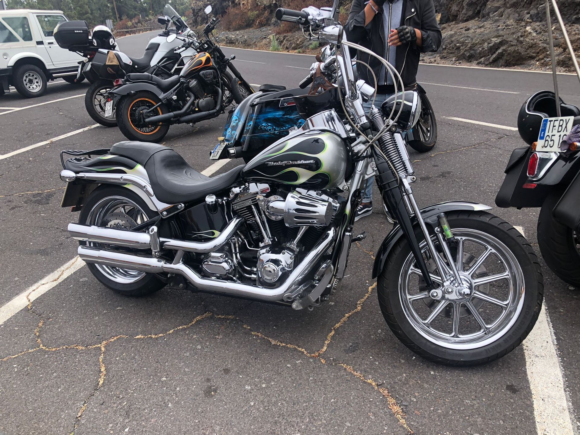 A group of motorcycles are parked in a parking lot.