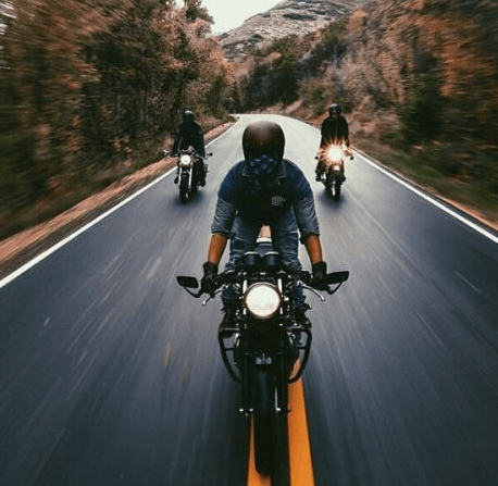 A group of people are riding motorcycles down a road