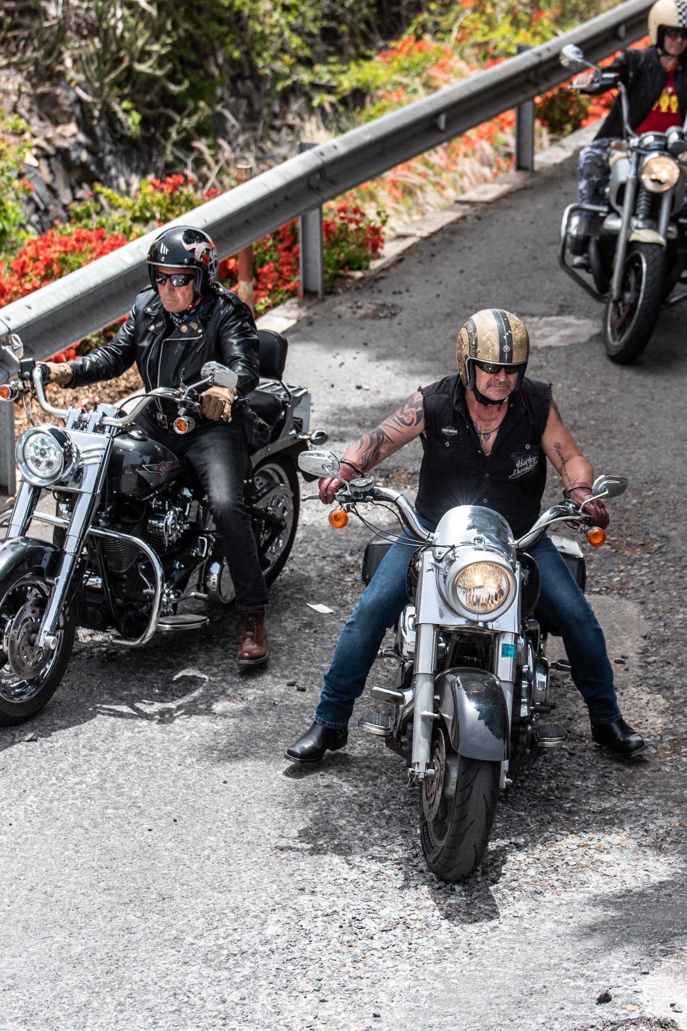 A group of people are riding motorcycles down a road.