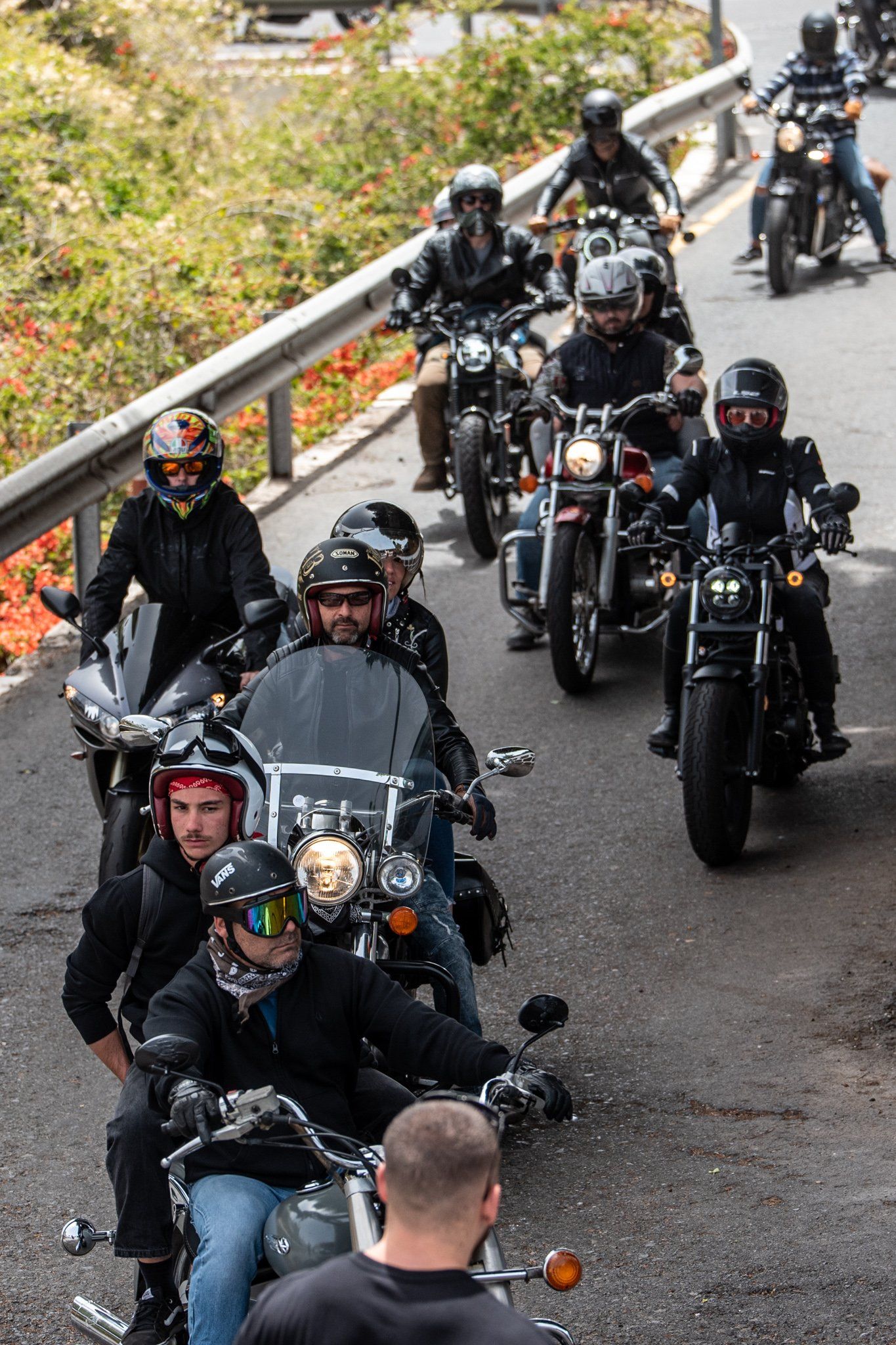 A group of people are riding motorcycles down a road.