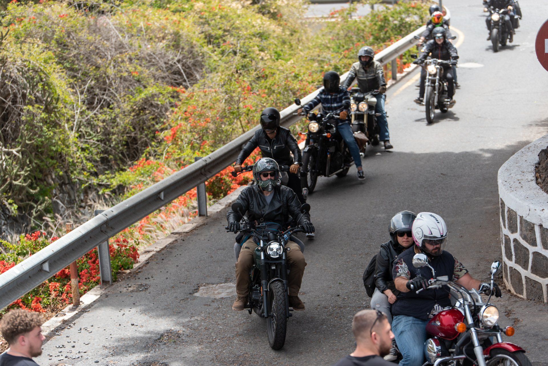 A group of people are riding motorcycles down a road.